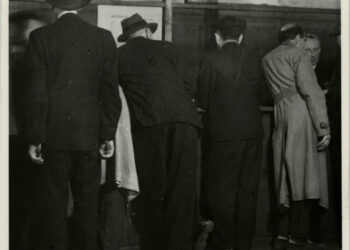 Lidé u přepážek s evidenčními čísly do transportů (zdroj: http://collections.jewishmuseum.cz)